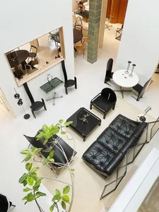 A modern living room with metallic black furniture, including a black sofa, chairs, and tables.