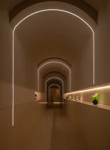 A minimalist hallway with a smooth concrete finish, illuminated by soft, warm lighting.