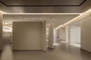 An minimalist, white-walled corridor with curved white pillars and a smooth, minimalist floor.