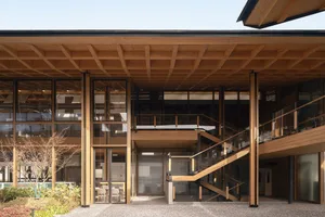 A modern office space featuring wooden beams and a staircase.