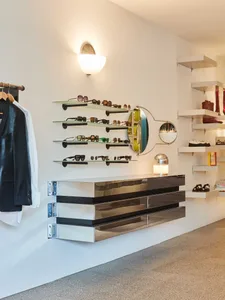 現代零售店內部，展示太陽眼鏡的金屬與玻璃懸浮式層架。