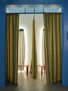 A modern retail storefront with striped curtains on the windows.