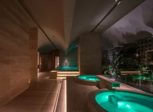 Modern spa interior featuring illuminated water features and glass elements.
