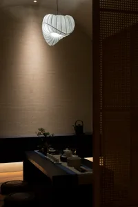 A modern tea room featuring a stylish paper lamp hanging from the ceiling.