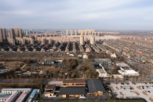 An aerial view of a modern urban development featuring concrete buildings and steel structures.