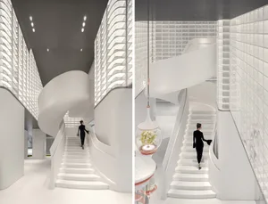 A sleek, modern staircase with white marble steps and walls, featuring a contemporary design.