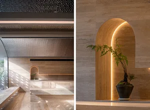A serene spa interior featuring natural stone walls and archways, illuminated by soft lighting.