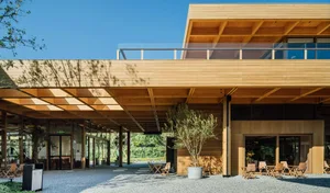 Modern wooden exterior of a coffee shop with outdoor seating and greenery.