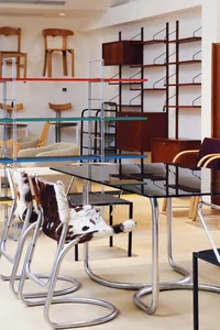 A modern office space featuring furniture made of metal, glass, and plastic.