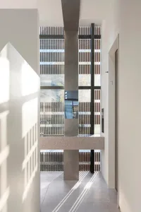 Modern corridor with concrete walls, floors, and columns.