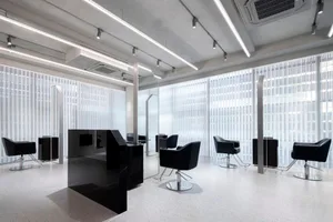 Modern salon interior with black metal chairs and glass dividers