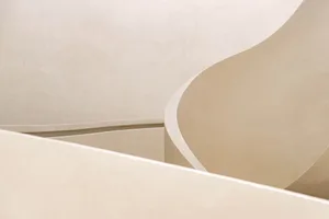 A minimalist, geometric interior design featuring neutral colors and smooth, rounded lines.