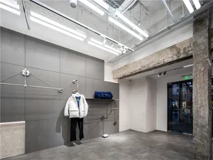 Industrial storefront with concrete walls, concrete columns, and overhead fluorescent lighting.