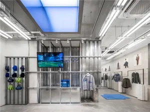 A minimalist retail space featuring metal, glass, and concrete materials.