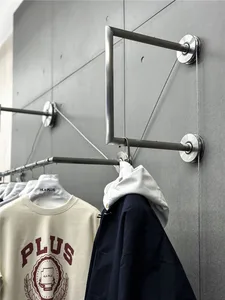 A modern clothing rack with metal rods and a string system for hanging clothes.