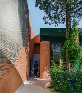 A modern exterior entryway featuring brick and concrete materials, with a person walking through the entrance.