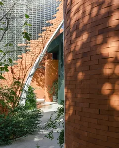 An outdoor hallway with glass and brick walls, showcasing modern architectural design.