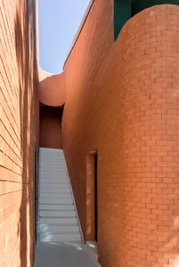 A modern minimalist interior with brick walls and a white staircase.