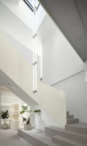 Modern, minimalist staircase with concrete steps and integrated lighting in a clean, white interior space.