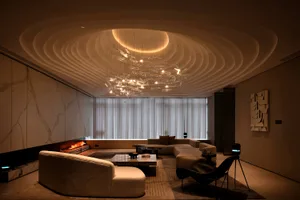 Modern living room with marble walls, glass chandelier, and leather furniture