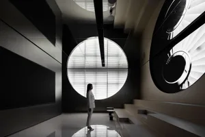 A minimalist modern lobby featuring a large circular glass window.