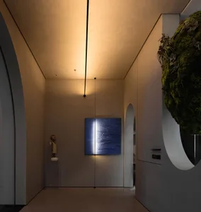 A modern minimalist lobby featuring lighting and metallic glass elements.