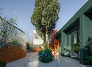 A modern residential exterior with glass and brick walls and concrete ground.