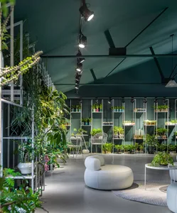 An industrial-style urban garden center featuring concrete and steel framework.
