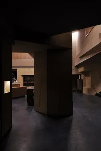 Concrete interior space with geometric shapes and warm lighting.