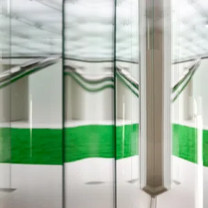 Glass corridor with green reflections and metallic details