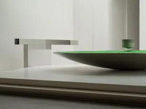 A modern interior design featuring a metallic table with a green surface.