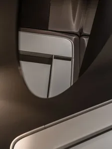 A close-up view of a window in an airplane's interior, featuring a plastic structure with a light bar.