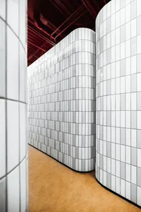 Curved white tiled walls with a red ceiling in a modern interior design space.