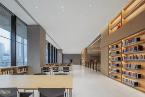 A modern industrial-style library with bookshelves and seating areas.