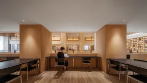 A serene library interior with wooden shelves and tables.