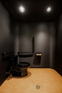 A minimalist bathroom with black fixtures and a light-colored floor.
