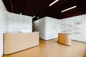 A minimalist spa interior with white tiled walls and cork flooring.