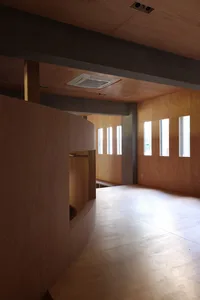 A modern interior space featuring walnut flooring and wooden walls