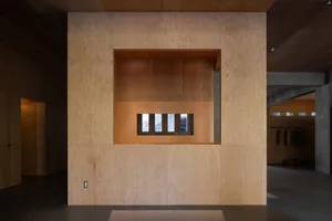 An image of a minimalist interior with wooden walls and a central cutout.