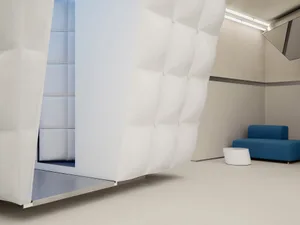 A modern office interior with textured white walls and a blue bench.