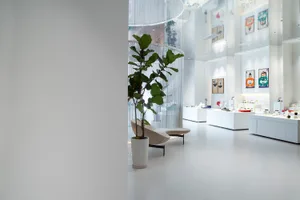 A minimalist retail storefront with white concrete materials and a clean, open space.