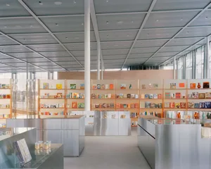 A modern bookstore with metal shelves displaying various books and products.
