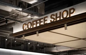 Modern, industrial-style coffee shop signage with metallic cladding.