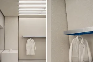 A modern clothing shop with a concrete-textured wall and minimalist design.