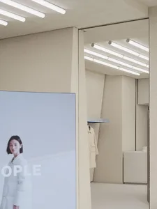 Modern retail space with a concrete floor, wooden walls, and a large image of a person in a white coat.