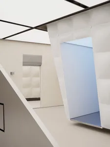 A modern interior space featuring a glass wall and white walls and floors