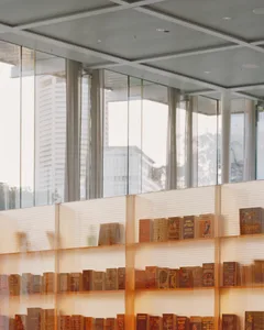 Glass shelves filled with books in a modern library setting.
