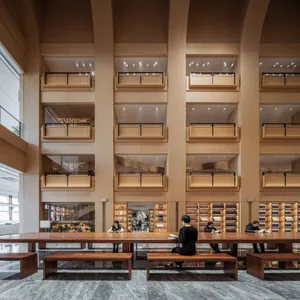 現代簡約圖書館室內，搭配天然木質家具與擺滿書籍的書架。