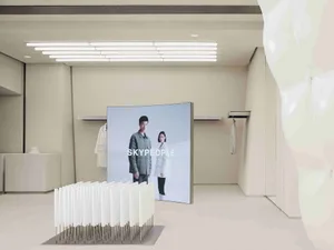 Modern retail storefront showcasing a digital display featuring two models and the brand name 'SKYPEOPLE'.