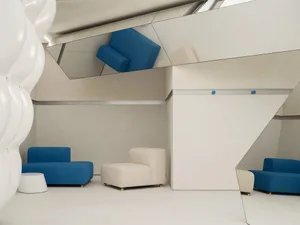 Modern lobby interior featuring textured concrete walls and floor, complemented by streamlined seating arrangements.